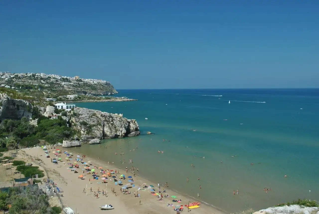 Peschici spiaggia Zaiana: una baia incantevole con sabbia dorata, ombrelloni colorati e il mare cristallino del Gargano.