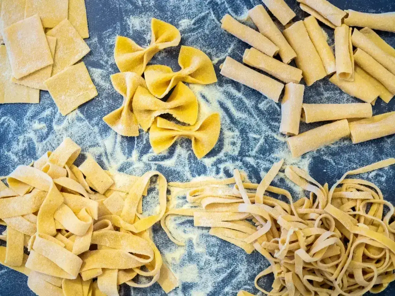 Różne rodzaje domowego makaronu: kwadraty, kokardki, rurki, tagliatelle i spaghetti. Zastanawiasz się, ile gotuje się makaron?