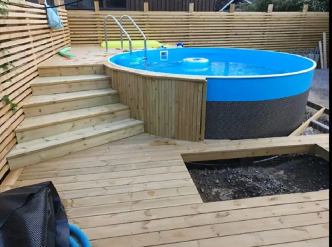 En härlig rund pool med en praktisk pooltrappa i trä. Perfekt för sommarens bad!