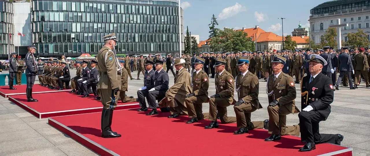 Uroczystość wojskowa, gdzie żołnierze klęczą na czerwonym dywanie. To może być ważny moment dla tych, którzy chcą wiedzieć, jak zostać oficerem WP.