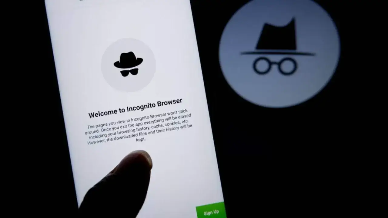 Palec dotyka ekranu telefonu, by włączyć tryb incognito. Ikona szpiega z kapeluszem i okularami symbolizuje prywatność.