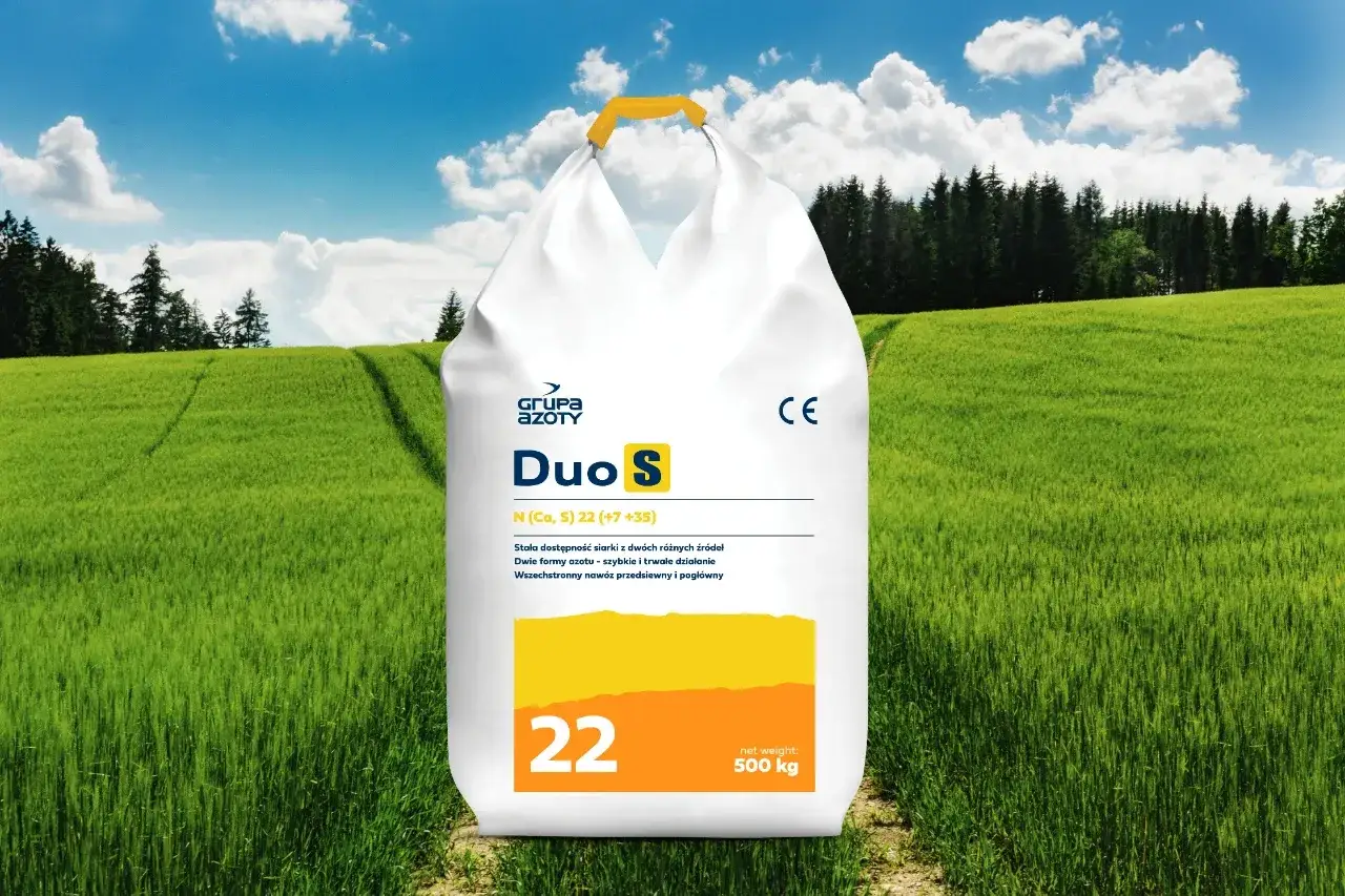 Worek nawozu Duo S z Grupą Azoty, zawierający fosforan, na tle zielonego pola i lasu.