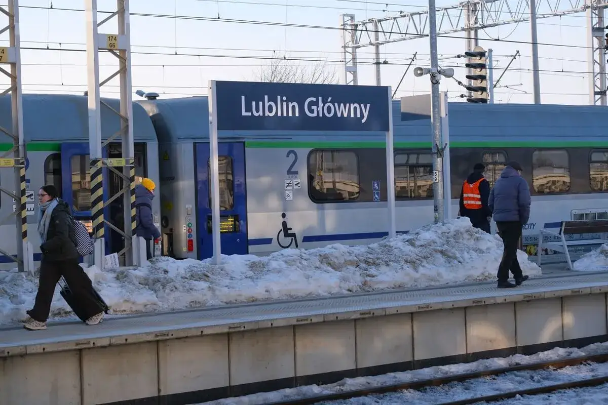 Zimowy dzień na stacji Lublin Główny. Pasażerowie z walizkami czekają na pociąg PKP, który zabierze ich w podróż, być może aż do Kołobrzegu.