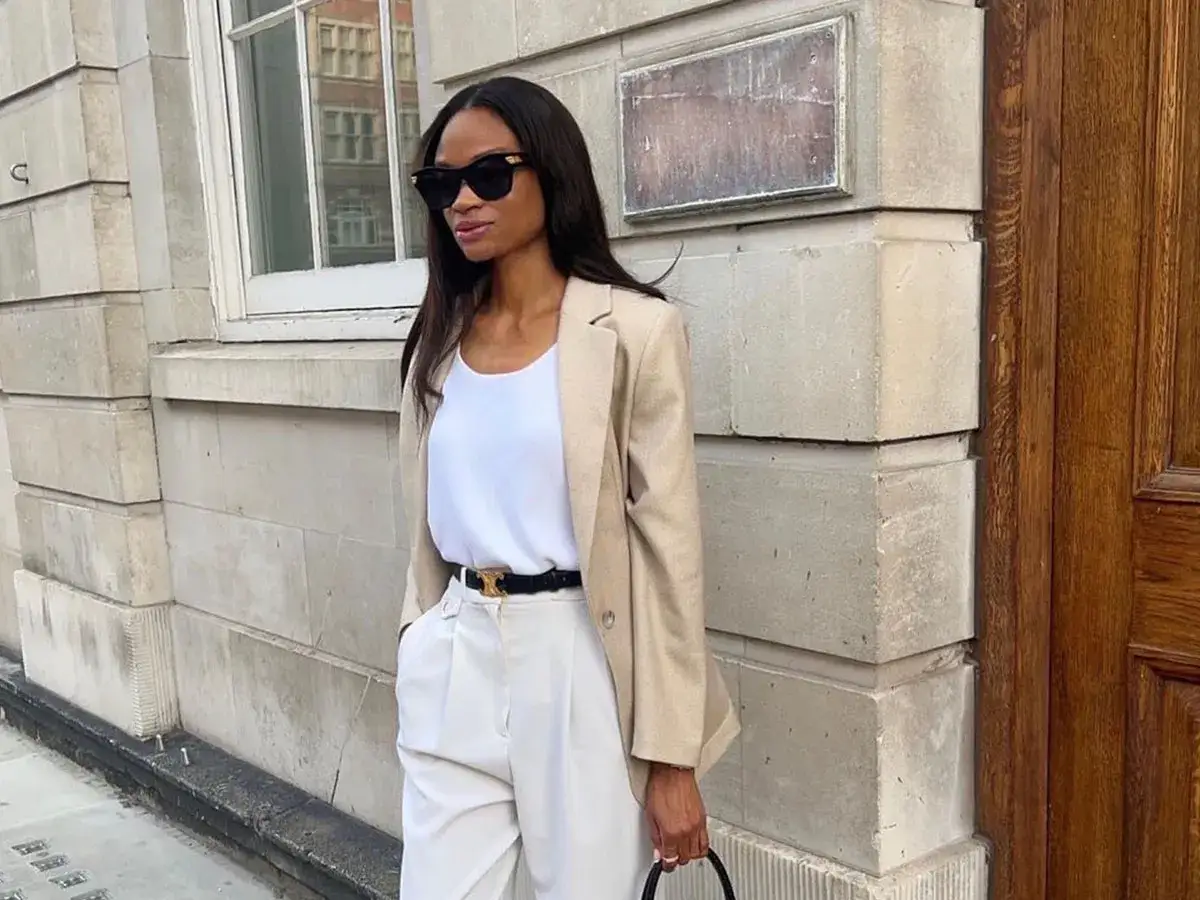 Elegantes Outfit mit Blazer: Eine Frau in einem beigen Blazer, wei&szlig;em Top und cremefarbener Hose, bereit f&uuml;r einen stilvollen Tag.