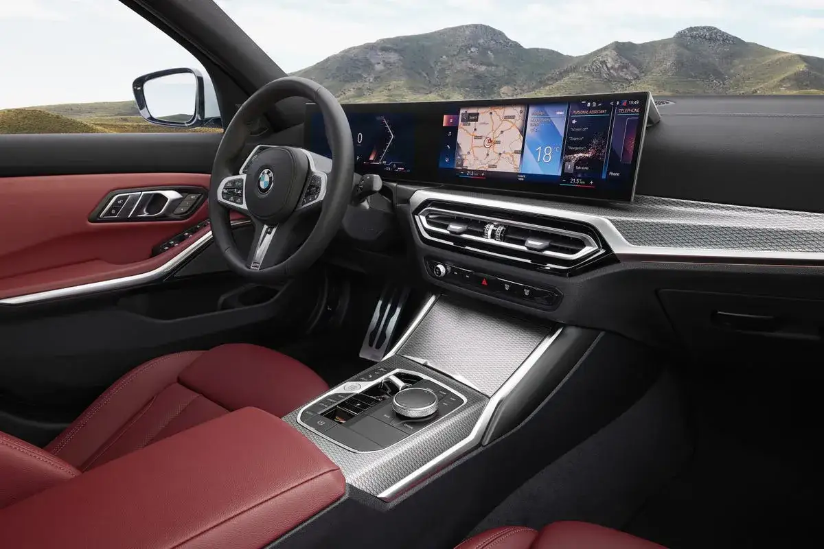 Wnętrze BMW 320i z czerwonymi skórzanymi fotelami i nowoczesnym panelem cyfrowym.