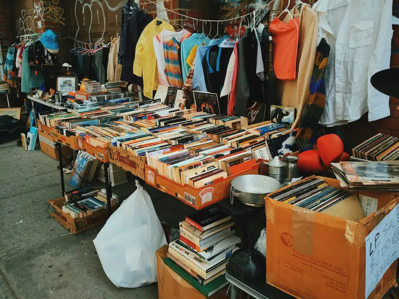 Bücher, Schallplatten und Kleidung auf einem Flohmarkt. Eine perfekte Flohmarkt-Checkliste für Schnäppchenjäger.