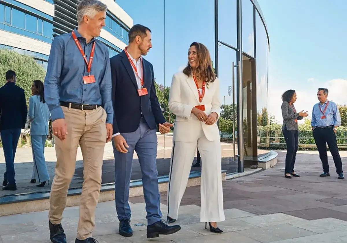 Profesionales discuten estrategias de negocios. Uno de ellos, con un traje blanco, parece haber completado un master business administration.