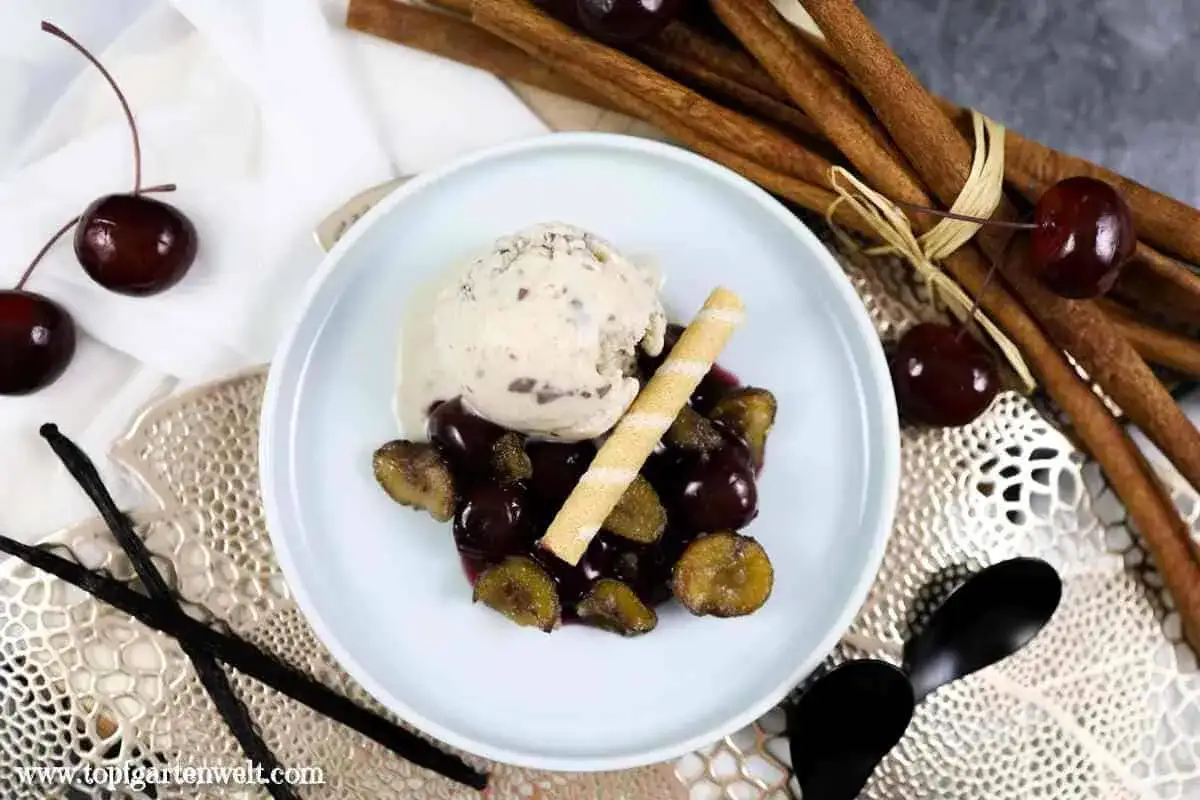 Ein cremiges Maronen Eis mit Kirschen und Zimtstangen.