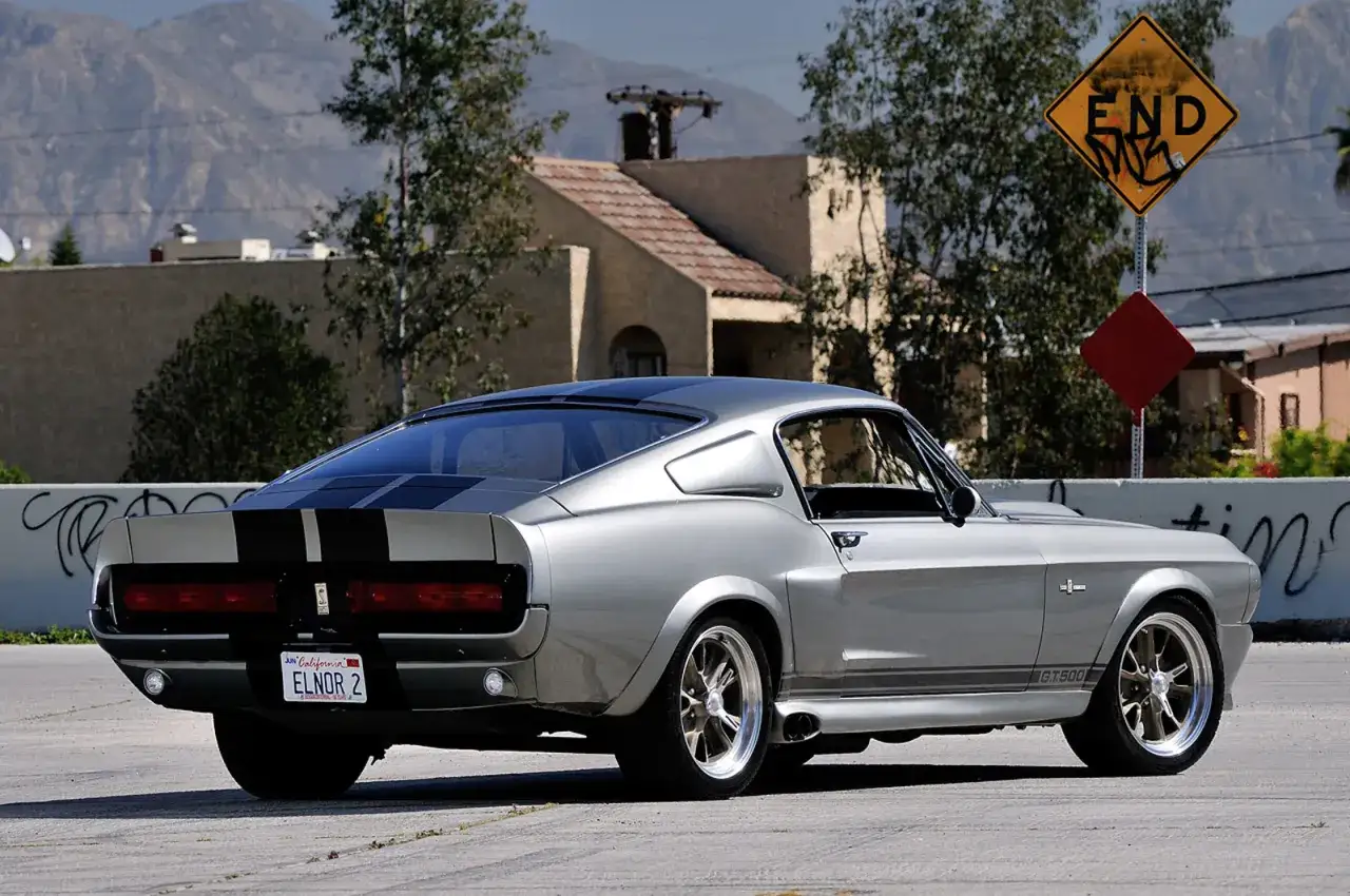 Srebrny Mustang Eleanor GT500 z czarnymi pasami, gotowy do akcji. Tablica rejestracyjna 