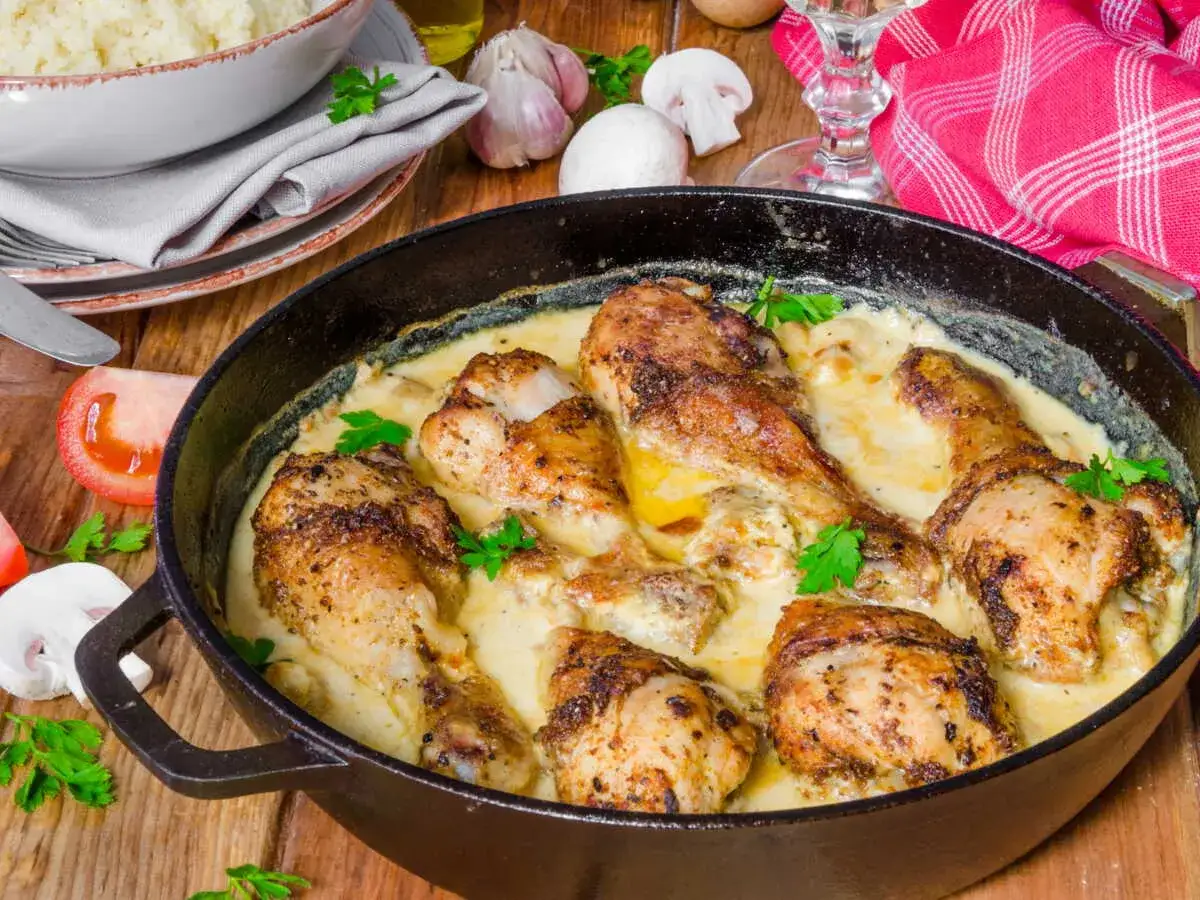 Délicieuse cuisse de poulet cookeo, dorée et nappée d'une sauce crémeuse, garnie de persil frais. Un plat savoureux prêt à être dégusté.