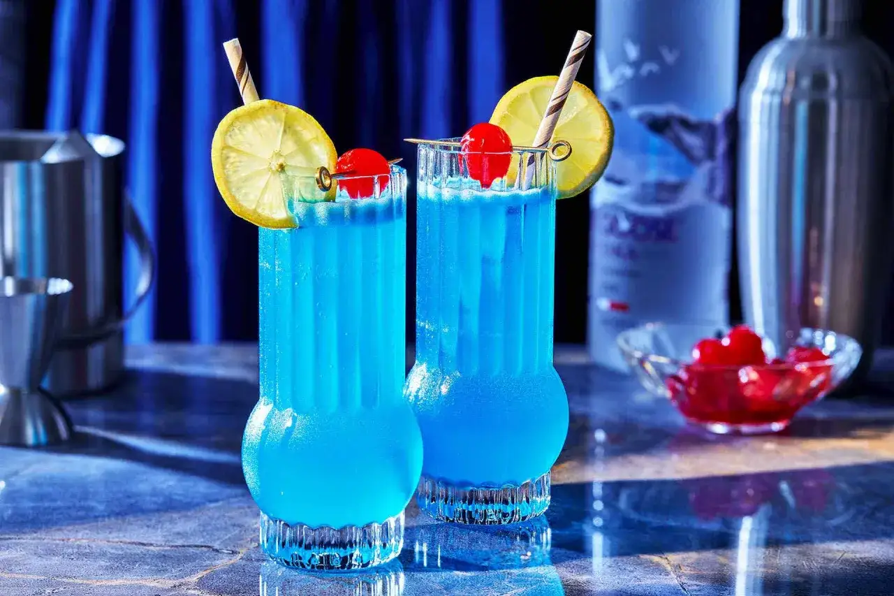 Dwa orzeźwiające blue lagoon drinki z cytryną i wiśnią, gotowe do podania.