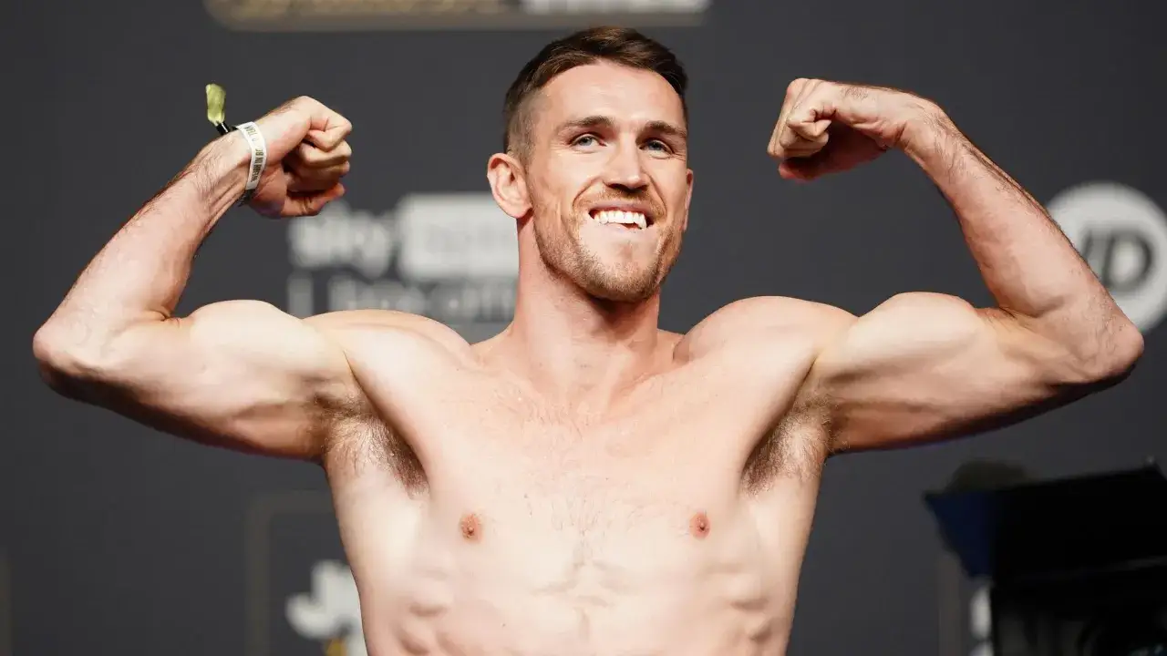 Boxer flexing, ready for the light heavyweight boxing weight limit. He's showing off his muscles, a testament to his training.