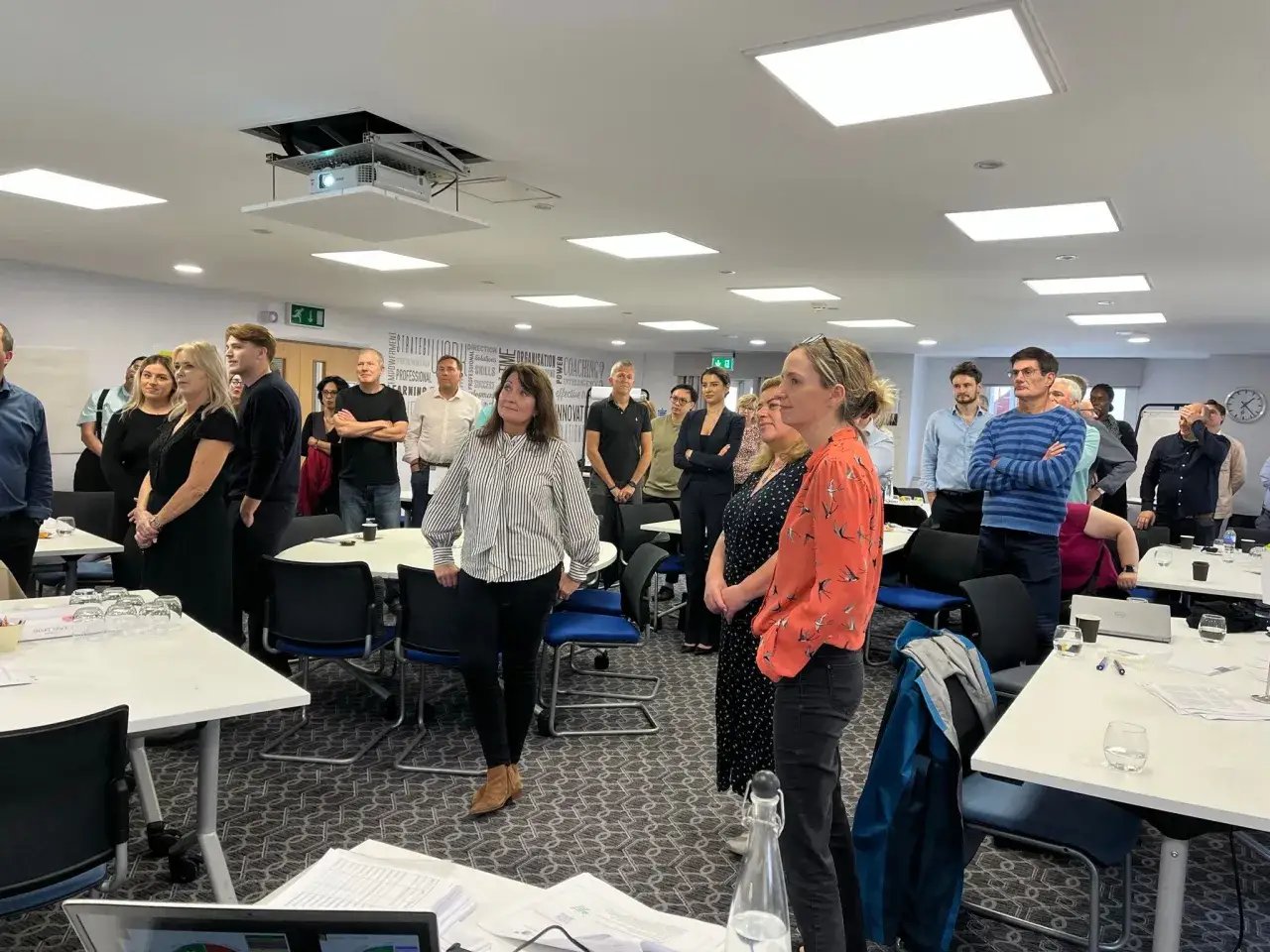 A diverse group of employees attentively listen during an HR session focused on employee engagement.