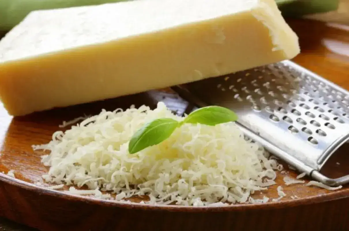 Tarty parmezan z bazylią i tarką. Czy parmezan jest wegetariański? Tradycyjnie nie, bo zawiera podpuszczkę zwierzęcą.