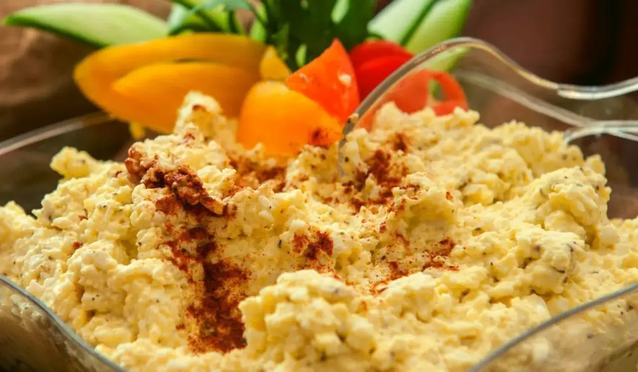 Puszysta pasta jajeczna bez majonezu, posypana papryką, podana z warzywami. Idealna na kanapki.