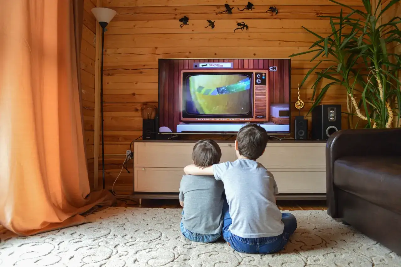 Dwóch chłopców ogląda bajkę na telewizorze. Dowiedz się, jak odbierać telewizję naziemną bez dekodera i ciesz się ulubionymi programami.