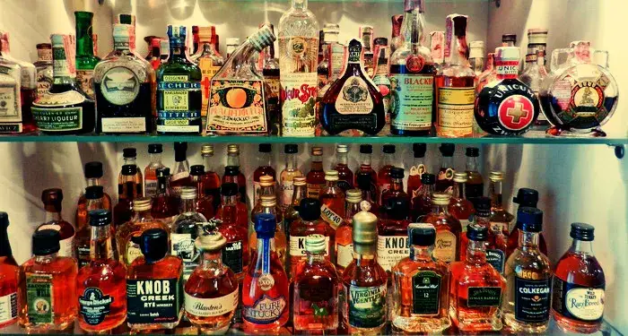 różne rodzaje alkoholi na półce w barze