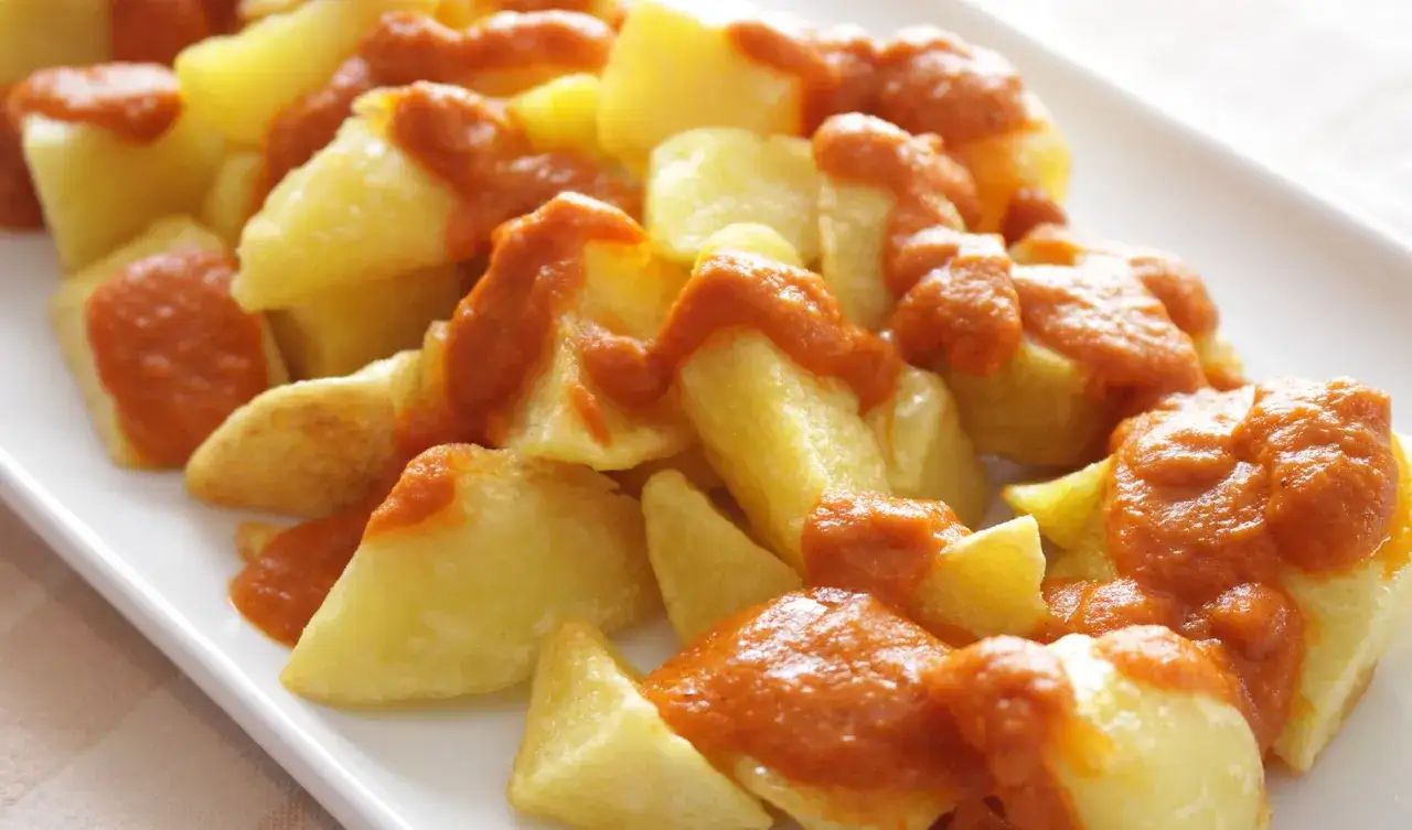 Patatas bravas, des pommes de terre coupées en dés et nappées d'une sauce rouge épicée.