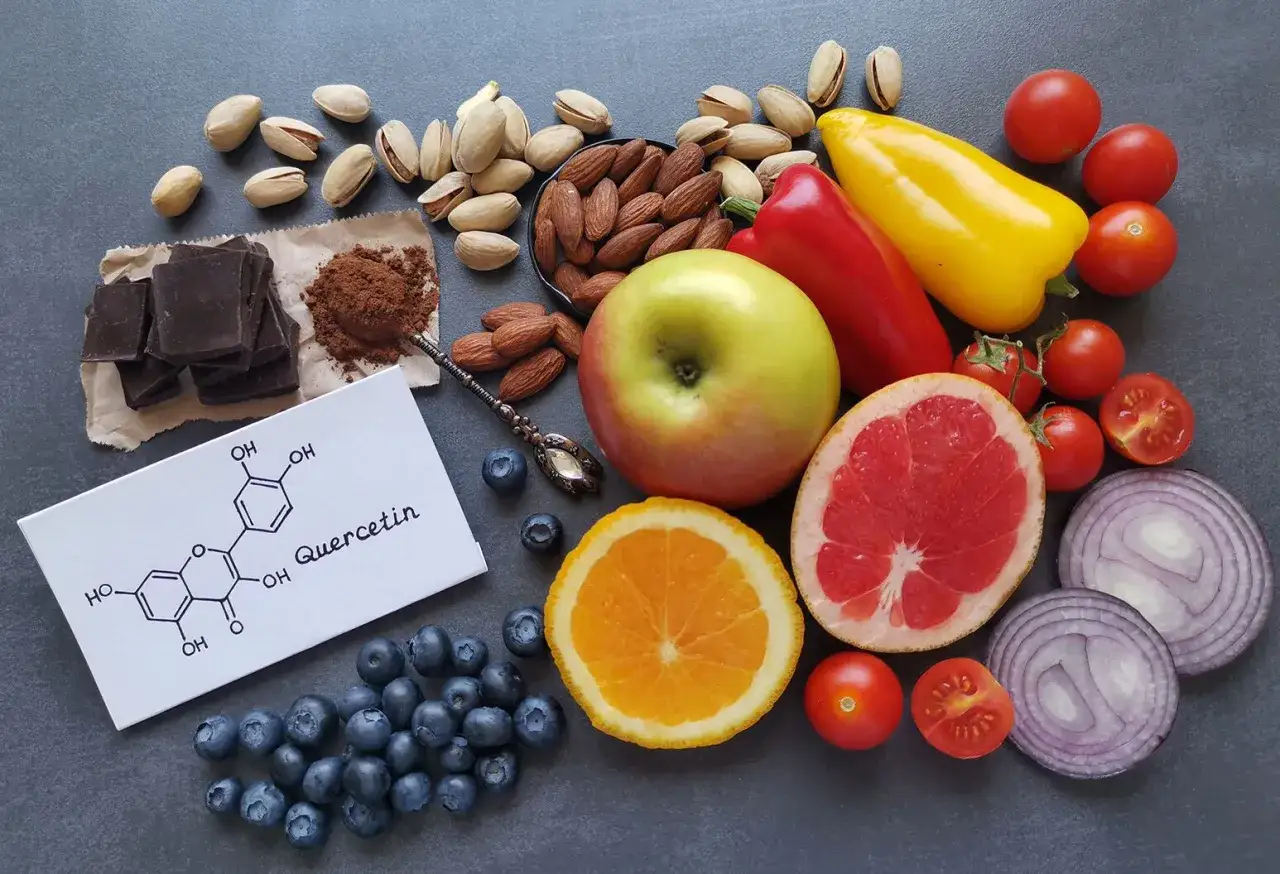 Quercetin-haltige Lebensmittel wie Beeren, Äpfel, Zwiebeln und dunkle Schokolade. Die chemische Struktur von Quercetin ist abgebildet.