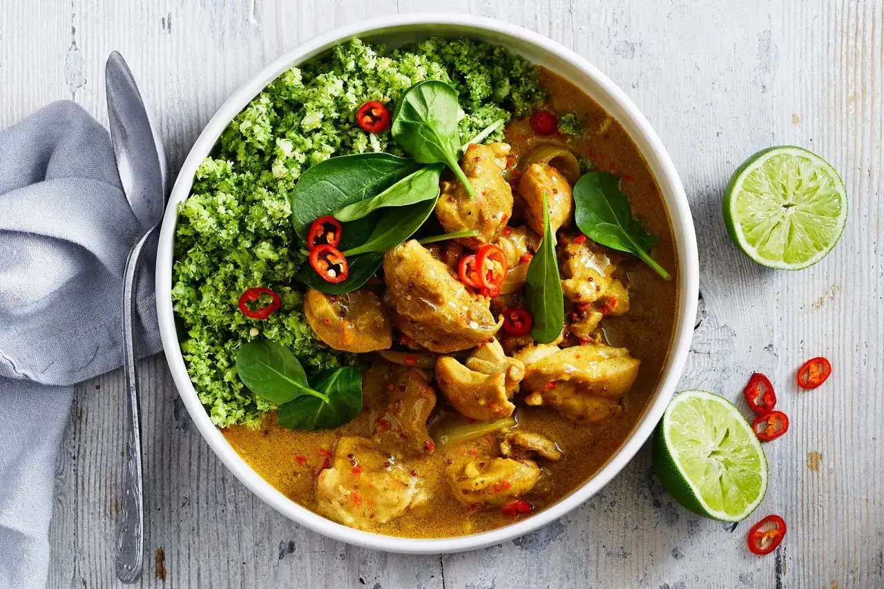 Aksamitne curry z mleczkiem kokosowym i kurczakiem, podane z zielonym ryżem brokułowym, świeżym szpinakiem i papryczką chili.