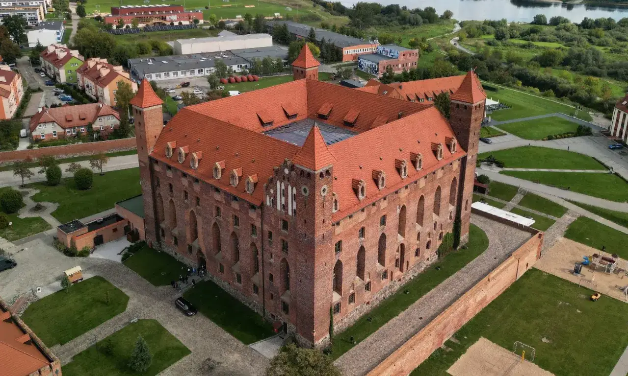 Zamek w Tczewie zaprasza na zwiedzanie. Potężna ceglana budowla z czerwonym dachem i wieżami prezentuje się okazale z lotu ptaka.