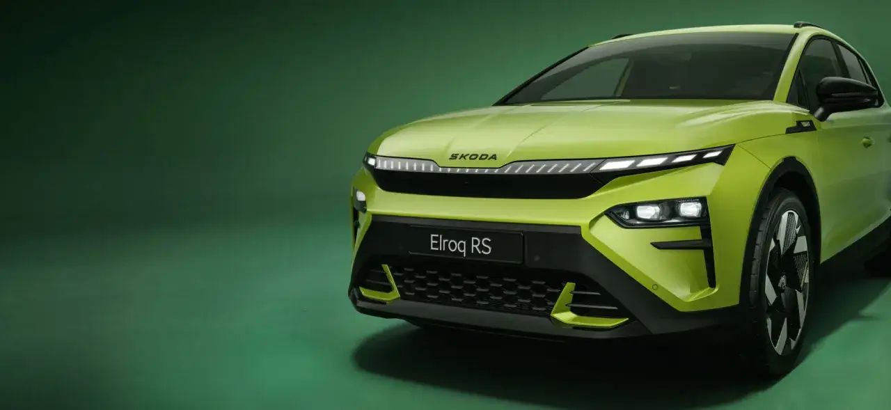 Nowa, elektryczna Skoda Elroq RS w jaskrawym, zielonym kolorze prezentuje się dynamicznie na tle zielonej ściany.