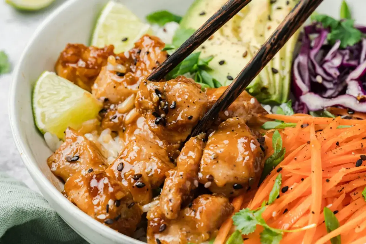 Leckeres H&auml;hnchen Teriyaki Rezept: Saftige H&auml;hnchenst&uuml;cke in Teriyaki-Sauce mit Reis, Avocado, Karotten und Limette.