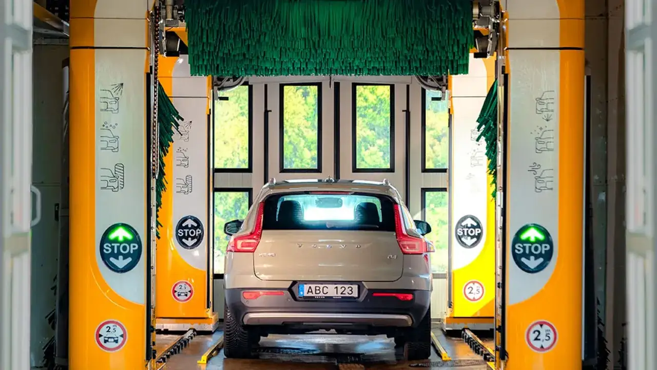 Volvo XC40 i en biltvätt, redo för autoclean + wax. Gröna borstar hänger redo.