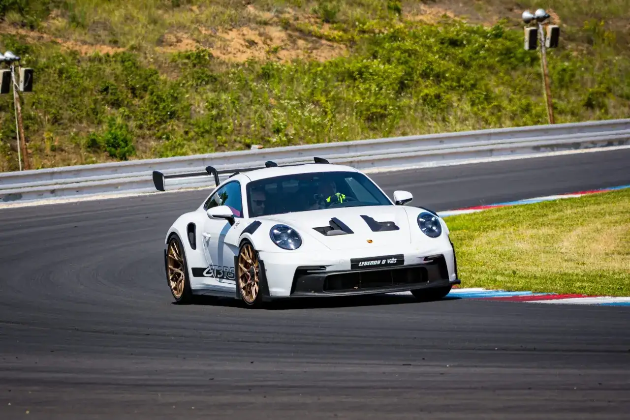 Białe Porsche 911 GT3 RS na torze wyścigowym. Zastanawiasz się nad porsche 911 gt3 rs cena? Ten model to marzenie wielu kierowców.