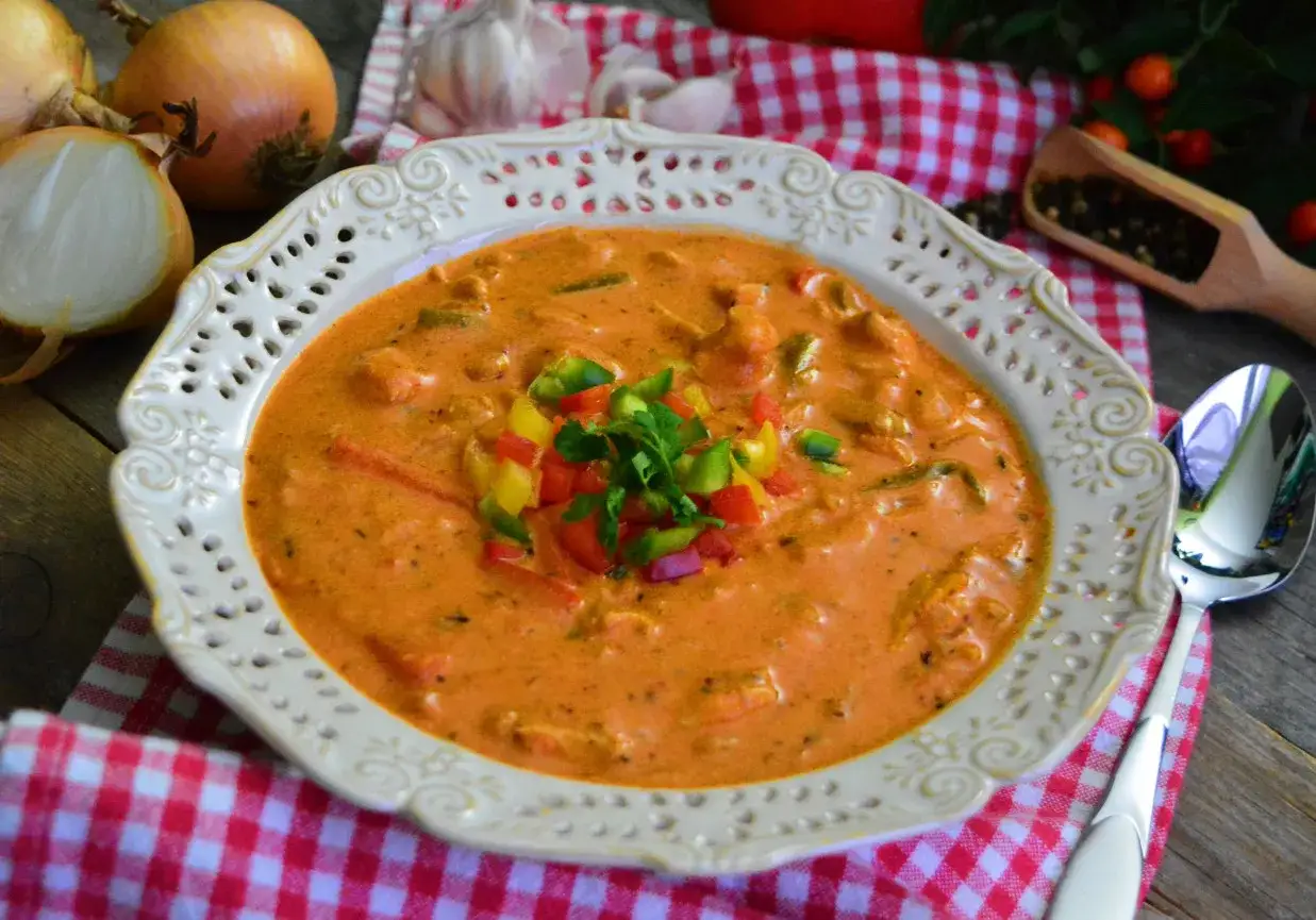 Zupa gyros Ania gotuje: kremowa, pomarańczowa zupa z kawałkami papryki i mięsa, udekorowana świeżą natką.