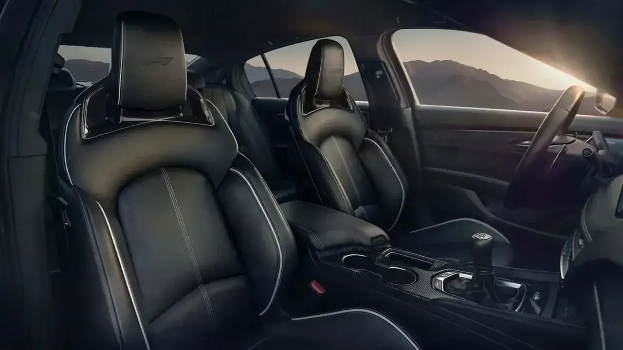 Wnętrze Cadillac CT5 z czarnymi, sportowymi fotelami i widokiem na góry.
