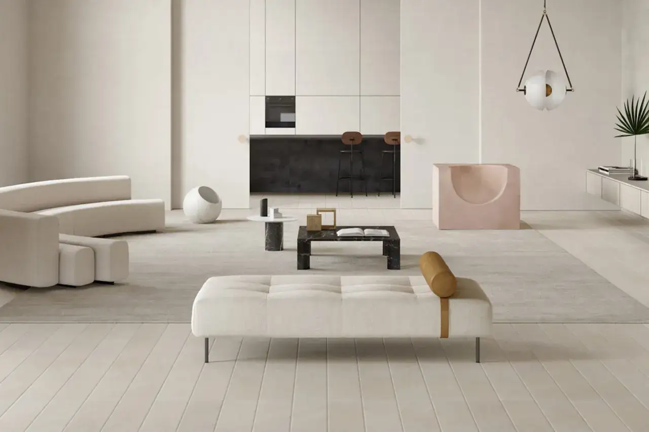Soggiorno moderno con divani curvi, tavolino in marmo nero e un pouf. I pavimenti in legno chiaro e i dettagli in pietra naturale creano un'atmosfera elegante.