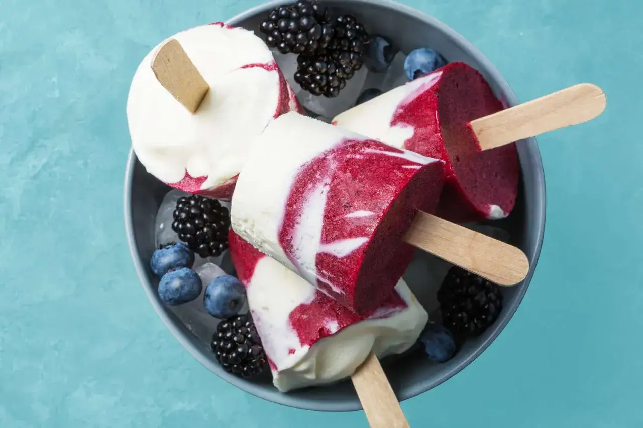 Lody na patyku z jogurtu i owoców leśnych, idealne na upał. Czy jogurt można mrozić? Tak, i wychodzą z tego pyszne desery!