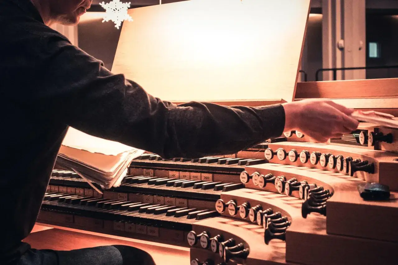 Mistrz gra na organach, studiując nuty. Poznaj tajniki, jak grać na organach, obserwując jego ruchy.