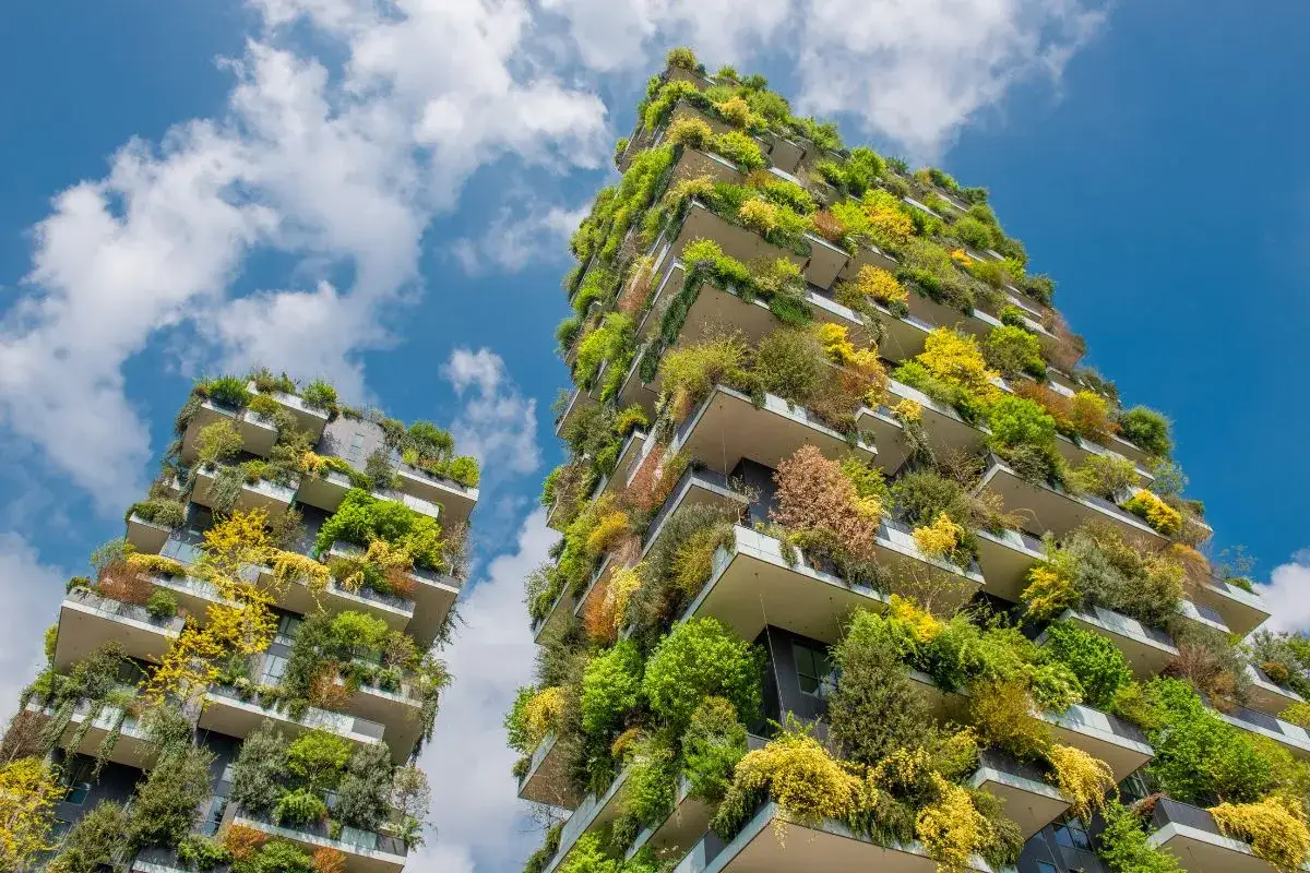 Bosco Verticale, capolavoro degli architetti famosi italiani, con terrazze ricche di vegetazione lussureggiante sotto un cielo azzurro.