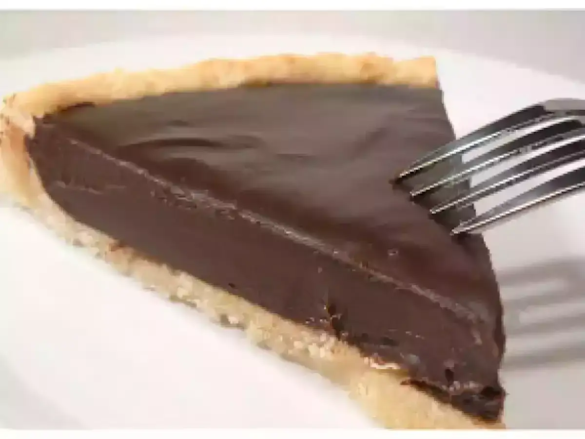 Une part de tarte au chocolat onctueuse, prête à être dégustée. C'est la meilleure recette de tarte au chocolat !