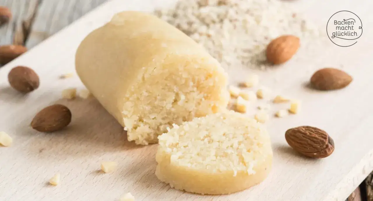 Frisch zubereitetes Marzipan, umgeben von Mandeln und gemahlenen Mandeln. So einfach ist es, Marzipan selber machen!