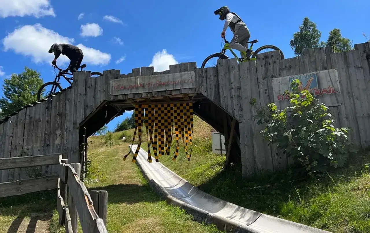 Två cyklister på en träbro i en bikepark i Tyskland. En perfekt plats för en äventyrlig semester.