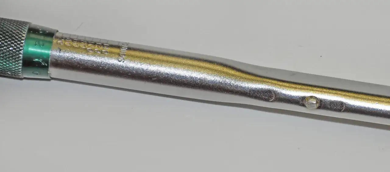 Close-up of a torque wrench, showing the adjustment collar and scale. This tool is essential for learning how to use a torque wrench correctly for precise tightening.