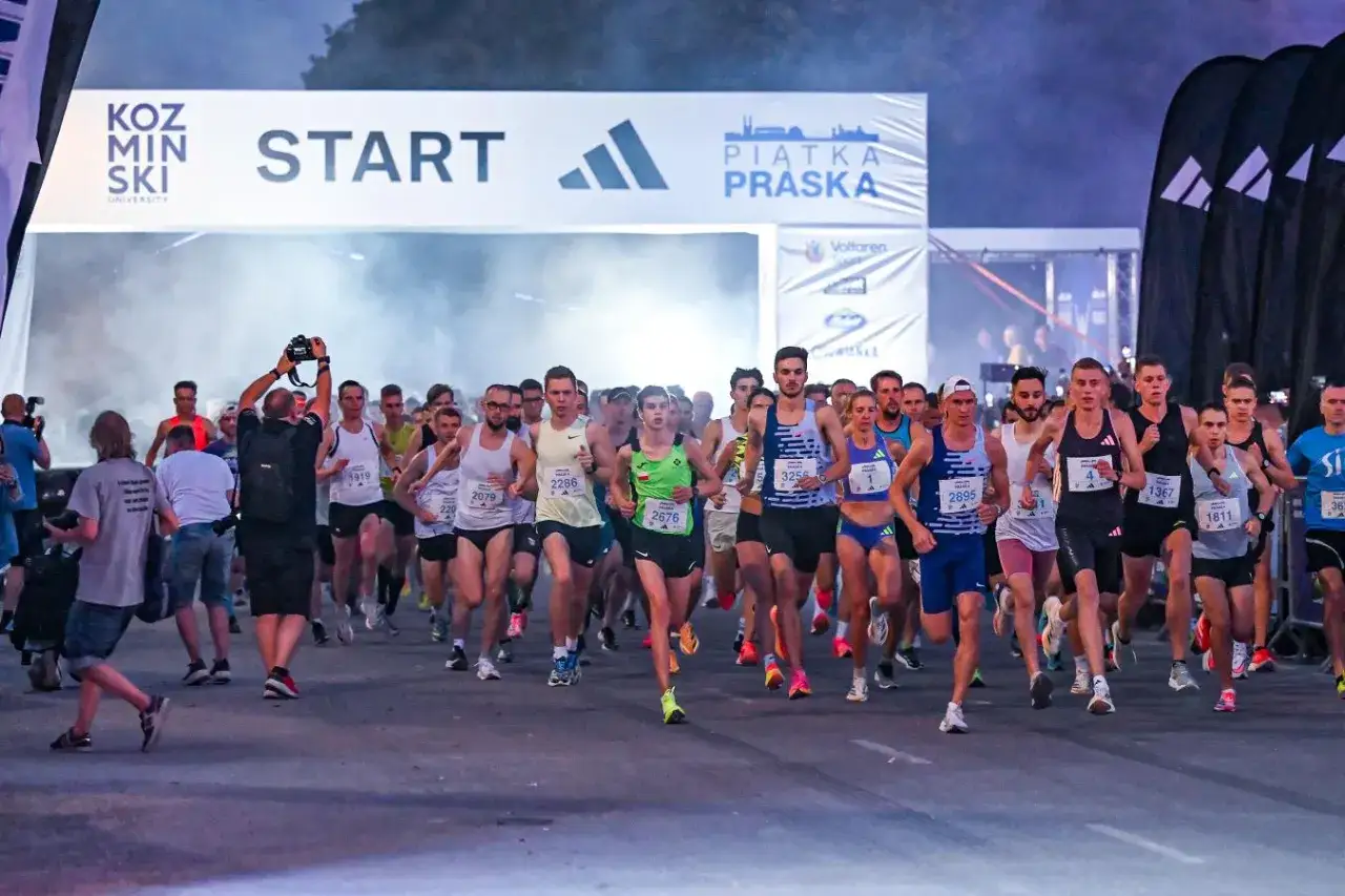 Start biegu na piątkę. Zawodnicy ruszają do rywalizacji, a fotograf uwiecznia ten moment.