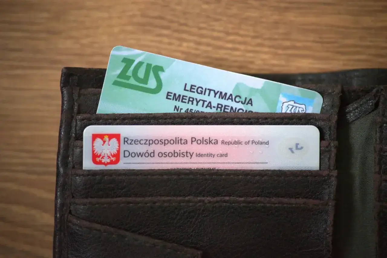 Brązowy portfel z dowodem osobistym i zieloną legitymacją emeryta ZUS.