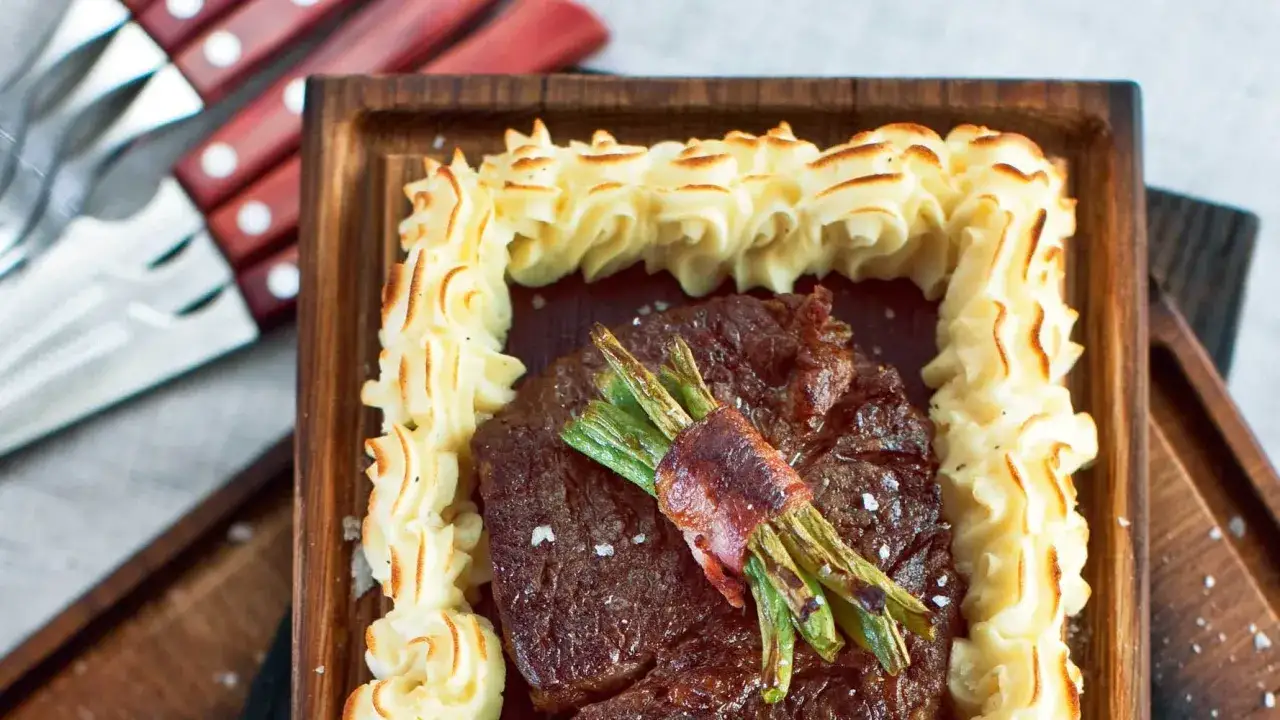En saftig biff med sparris inslagen i bacon, omgiven av krispig potatispur&eacute;. Ett perfekt plankstek recept f&ouml;r en festm&aring;ltid.