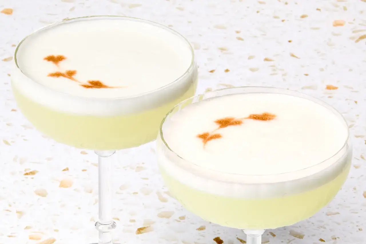 Tv&aring; vackra Pisco Sour-drinkar med ett dekorativt m&ouml;nster p&aring; skummet. Perfekt f&ouml;r ett pisco sour recept.
