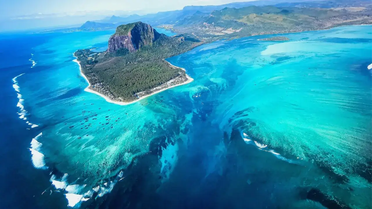 Spektakul&auml;rer Blick auf den **Mauritius Unterwasser Wasserfall**, wo Sand und Sedimente wie ein riesiger Strudel ins tiefe Blau st&uuml;rzen.