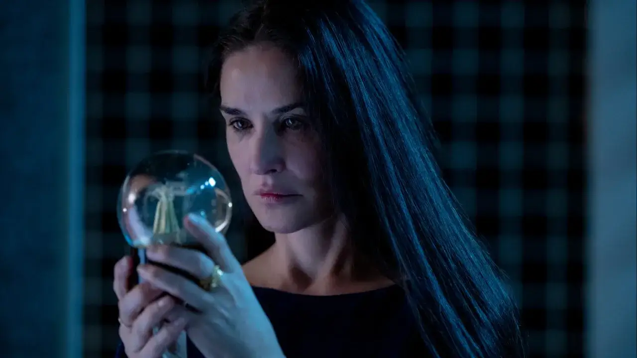 La donna osserva una sfera luminosa, forse un oggetto misterioso. La sua espressione è intensa, come in una recensione di una sostanza sconosciuta.