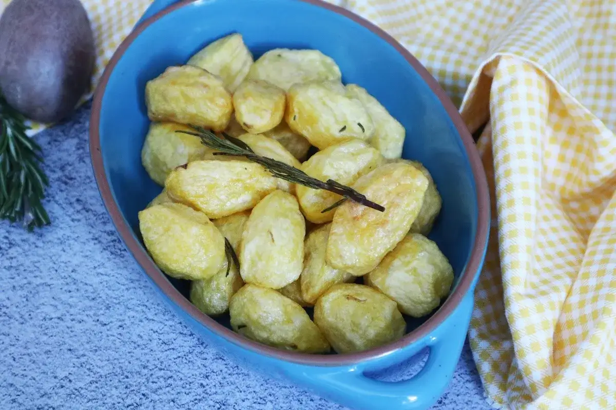 Patate novelle dorate e croccanti in friggitrice ad aria, guarnite con rosmarino fresco.