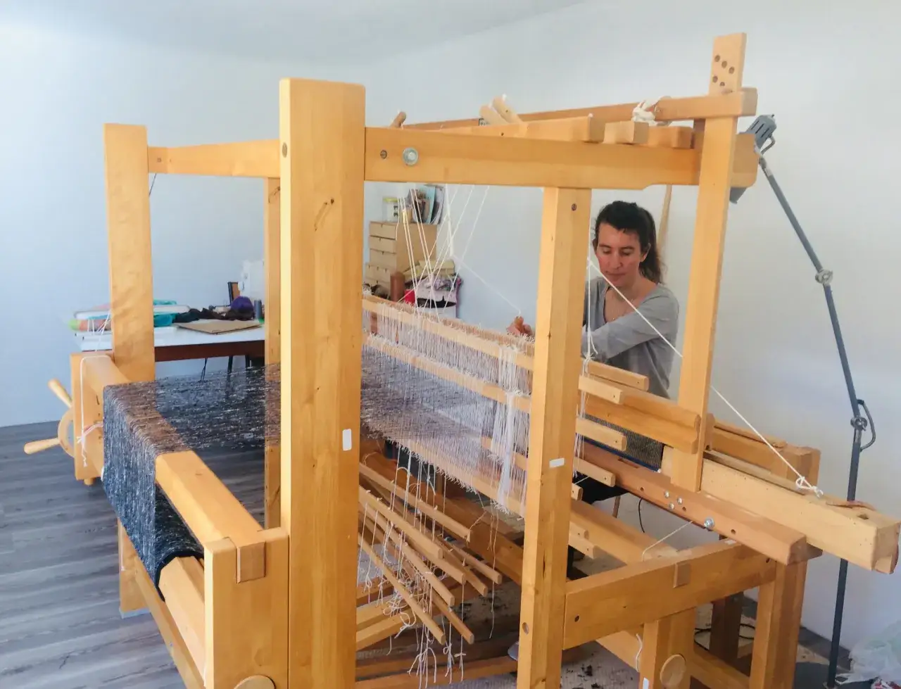 Une femme pratique le tissage sur un m&eacute;tier en bois. Un art ancestral, le tissier m&eacute;tier, prend vie sous ses mains habiles.