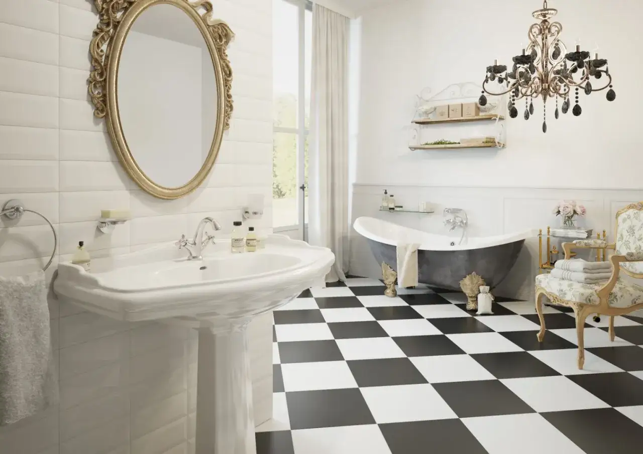 Elegancka łazienka z wanną wolnostojącą, umywalką i ozdobnym, złotym lustrem w stylu retro.