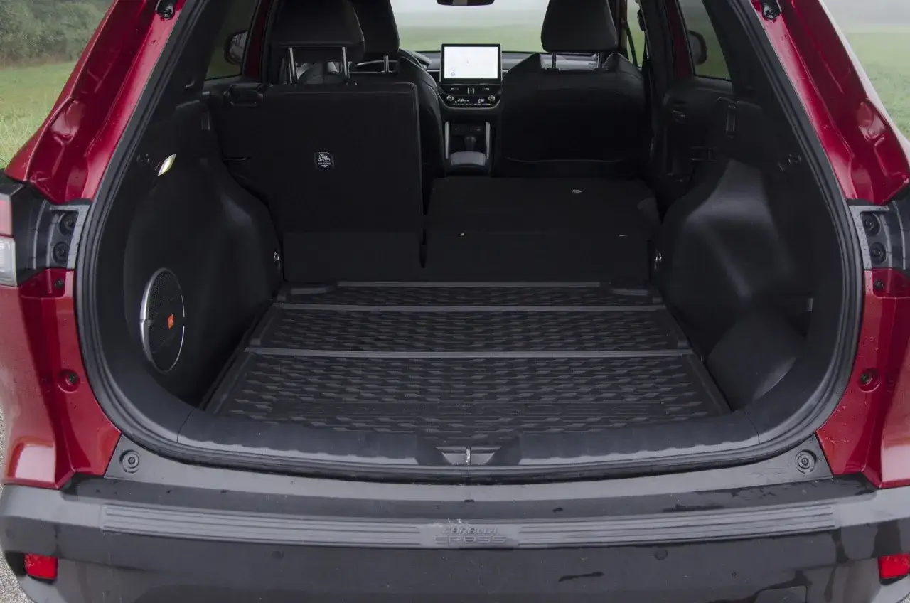 Bagażnik czerwonego **toyota corolla suv** z podniesioną klapą. Widać gumową matę, głośnik JBL i złożone tylne siedzenia.