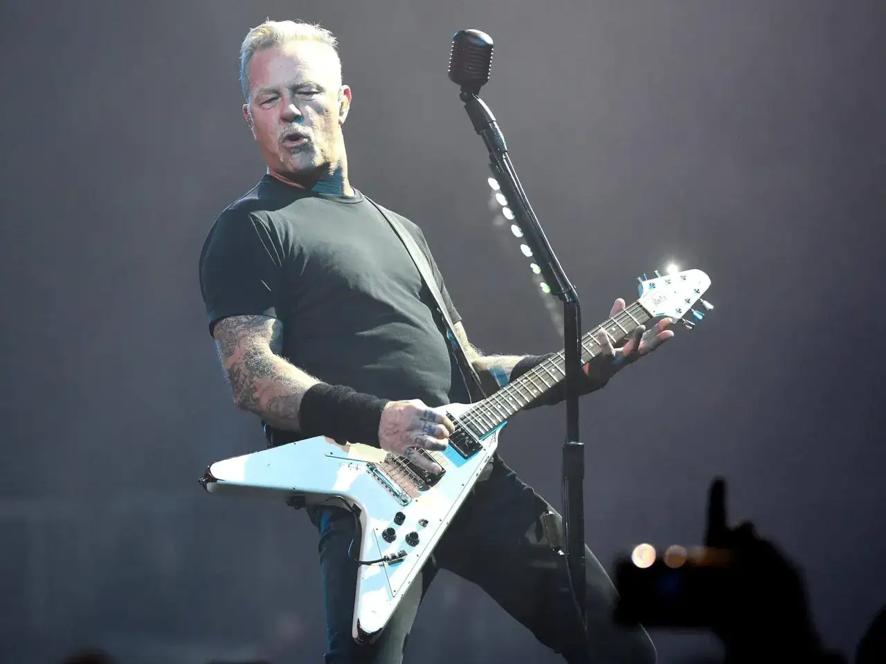 James Hetfield, um 2000, rockt die Bühne mit seiner weißen Flying V Gitarre.